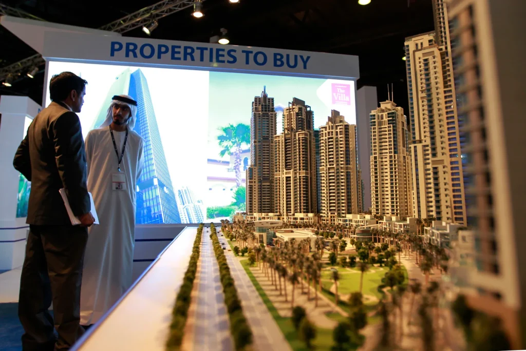 Investors viewing a Dubai real estate development model at an international property exhibition.